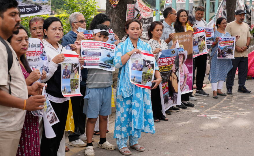 Relatives of recent flash flood victims hold banners urging authorities to step up efforts to find their missing loved ones during a demonstration in Kathmandu, Nepal, on Monday.