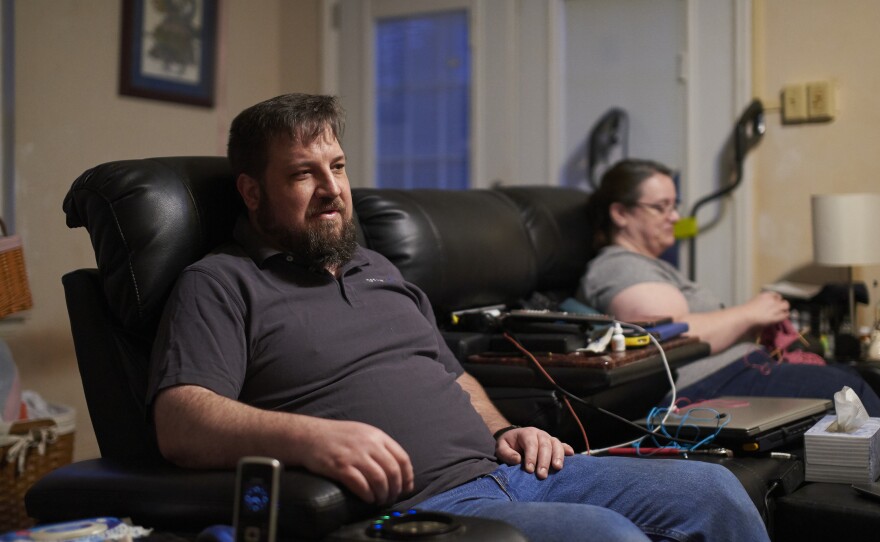 Drew Lehman and his wife, Laura, sit on the family's big leather couch. Lehman says it's the most comfortable place for him.