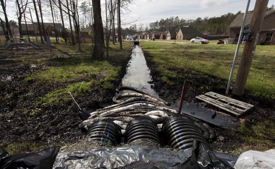 Spilled crude oil is seen in a drainage ditch near evacuated homes near Starlite Road in Mayflower, Ark., on March 31. An Exxon Mobil pipeline carrying Canadian crude oil was shut off after a ruptured on March 29, causing an evacuation of 22 homes.