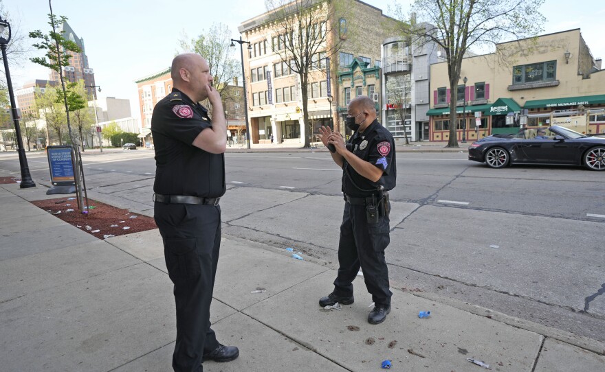 Milwaukee School of Engineering public safety officers investigate the scene of a shooting near the corner of North Water Street and East Juneau Avenue in Milwaukee on Saturday.