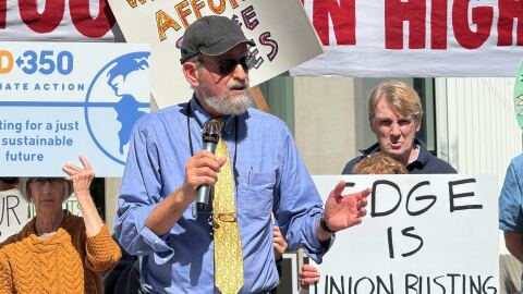 Craig Rose, director of Public Power San Diego, advocates for a nonprofit, publicly owned utility company outside of the headquarters for SDG&E's parent company on Thursday, Feb. 26, 2026.