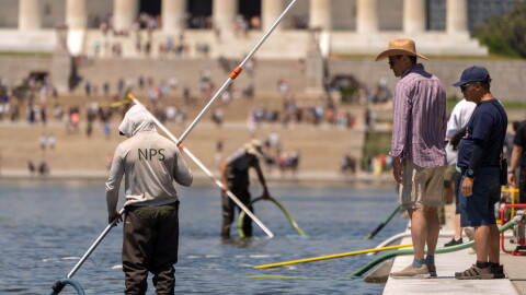 Visitors watch as National Park Service employees use vacuums to clean the Lincoln Memorial Reflecting Pool, Saturday, June 20, 2026, in Washington.