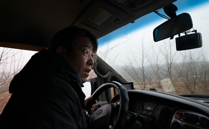 Kim Seung-ho drives through the CCZ looking for birds out his van window.