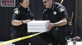 T. Abbott, left, and John Lopes, right, from the Sacramento County Sheriff's crime scene investigation office, conference about boxes of evidence gathered from the home of murder suspect Joseph DeAngelo, Thursday, April 26, 2018, in Citrus Heights, Calif. 