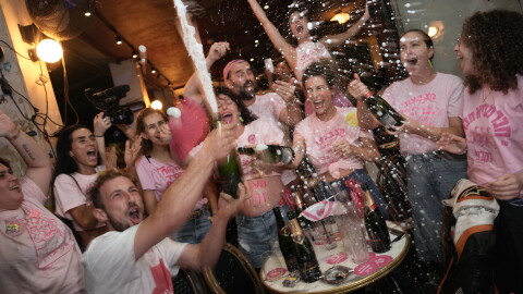 People spray sparkling wine as they celebrate early exit poll results for Israel's general election in Tel Aviv, Israel, Tuesday, Oct. 27, 2026.