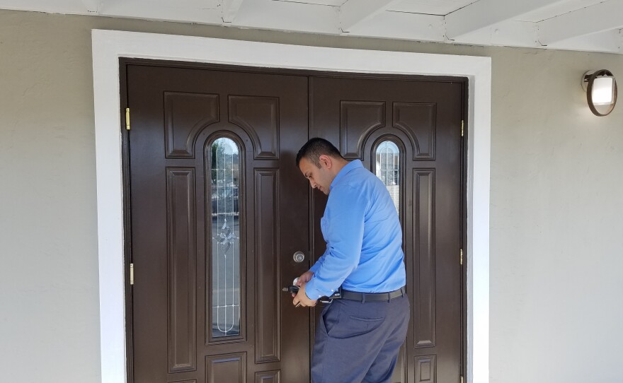Mike Aqrawi opens the door to his new real estate office in El Cajon, Oct. 15, 2019.