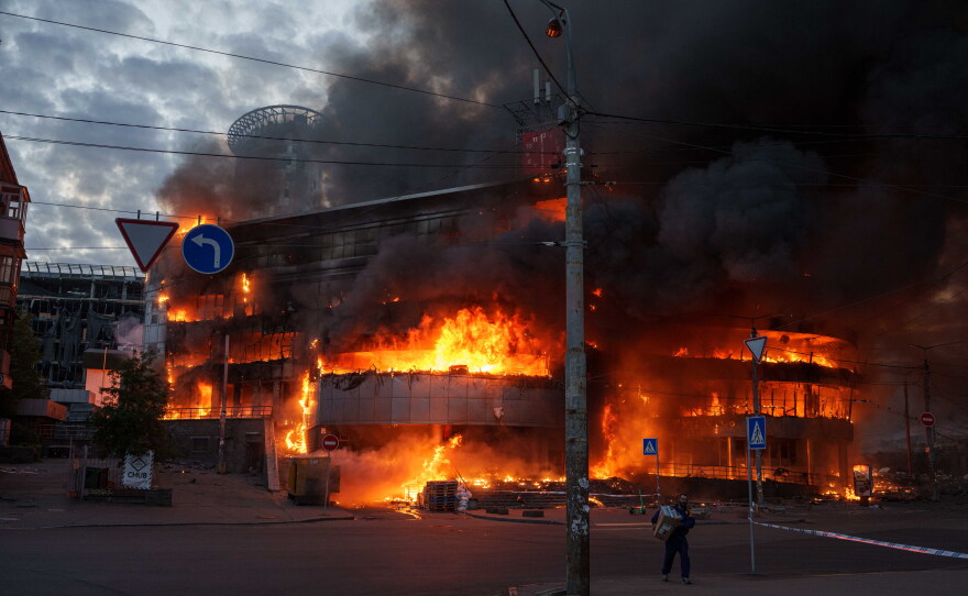 A man carries a box from a burning trade center after a Russian strike on Kyiv, Ukraine, on Sunday, May 24, 2026.