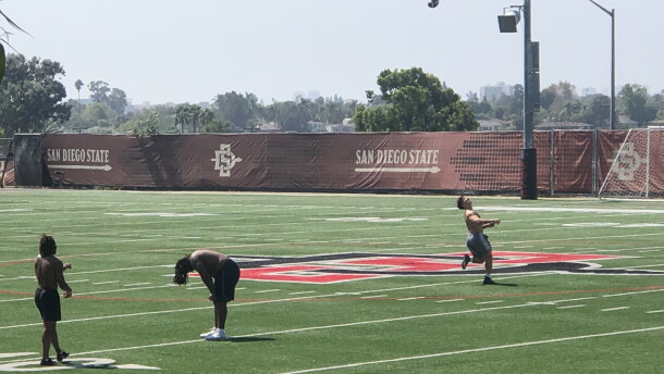 Three SDSU football players practice on a campus football field, Sept. 25, 2020.