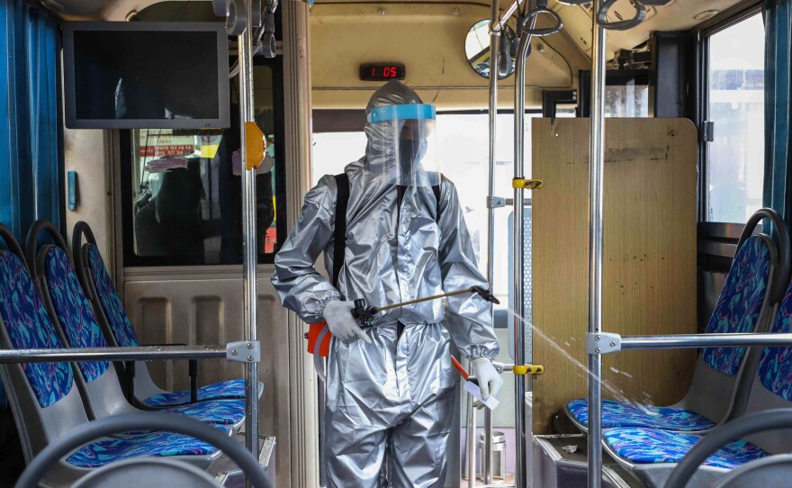 A worker disinfects the inside of a bus in Addis Ababa, Ethiopia. Transit agencies are taking new steps to reduce the risks for riders during the pandemic.