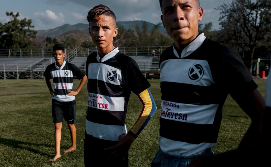 Rodney Ospino (center) listens to his coach during rugby practice at Hacienda Santa Teresa. Some 2,000 mostly poor youngsters from the surrounding neighborhoods play rugby at the estate as part of a program to deter them from joining gangs.