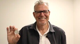 Artist Christopher Polentz holds a coin featuring his design on Thursday, June 4, 2026.