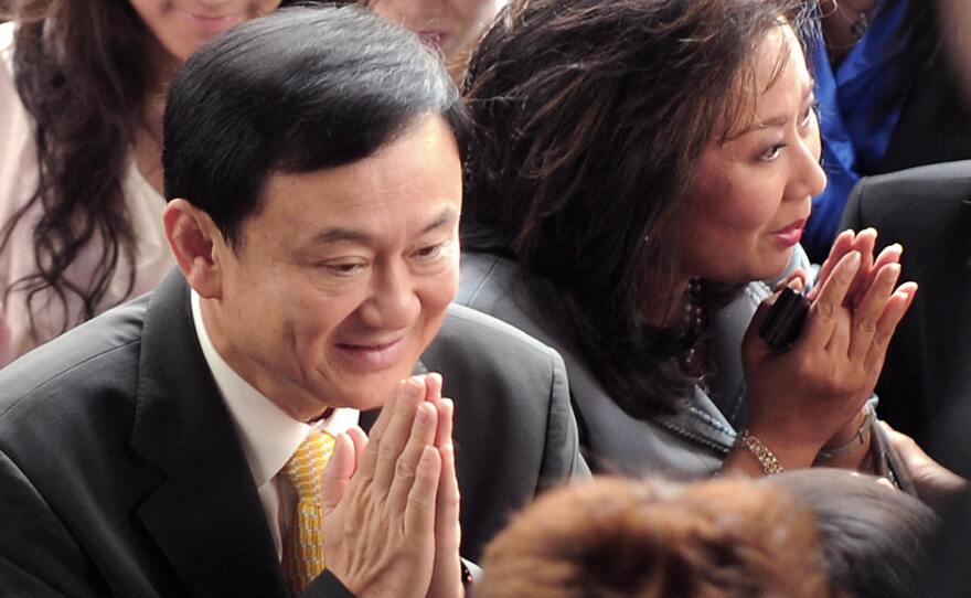 Thailand's deposed prime minister, Thaksin Shinawatra (left), and his wife, Pojaman, greet supporters on arrival at a court in Bangkok in July 2008. He was convicted on conflict of interest charges and lives in self-imposed exile.