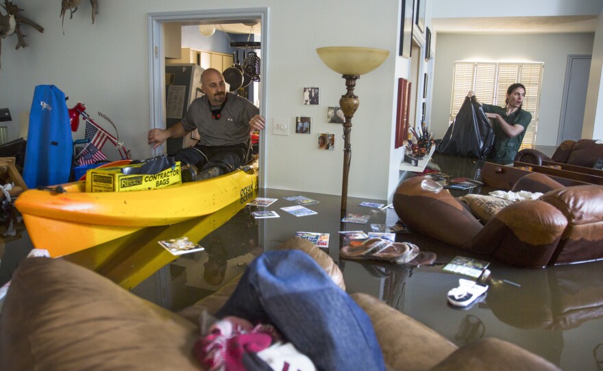 Larry Koser Jr. (left) and his son, Matthew, look for important papers and heirlooms inside his house after it was flooded by heavy rains from Hurricane Harvey.