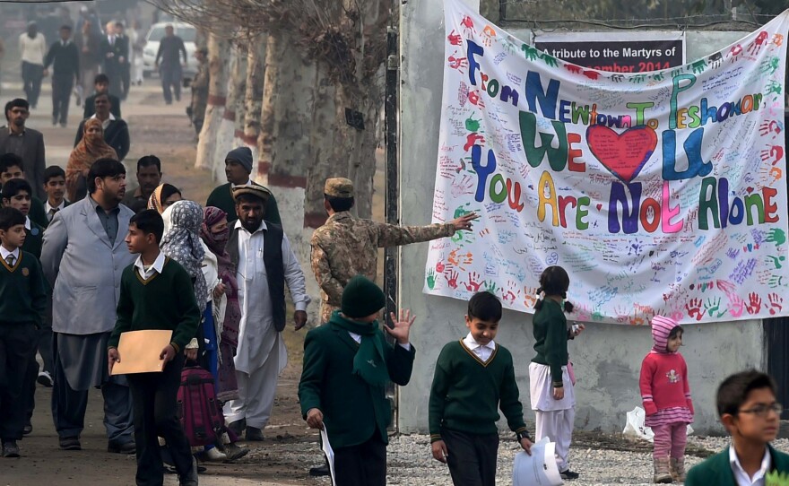 Pakistani parents leave the Army Public School with their children after it was reopened on Jan. 12. Most of the surviving students and teachers returned to the school.