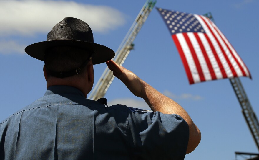 A Massachusetts state trooper salutes Wednesday during the memorial service for Massachusetts Institute of Technology (MIT) police officer Sean Collier on the school's campus in Cambridge, Mass.