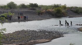 Four senior U.S. Border Patrol agents cross the Rio Grande at Big Bend National Park, Texas as a crowd gathers to greet them on the Mexican side. (Photo by Lorne Matalon)
