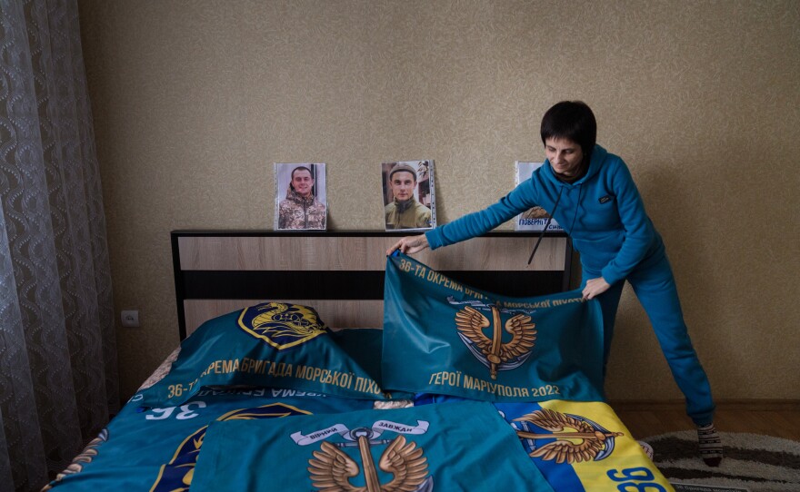 Nataliya Kucherenko drapes a flag over the bed in her son's room in the Sumy region of Ukraine. He was captured by Russian forces in Mariupol and Kucherenko waits for him to be returned.