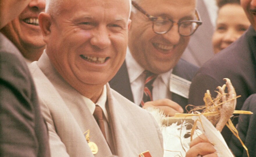 Russian Premier Nikita Khrushchev receives a turkey from President Dwight D. Eisenhower during his state visit. The political leaders are at Garth Farm, a turkey farm in Iowa.
