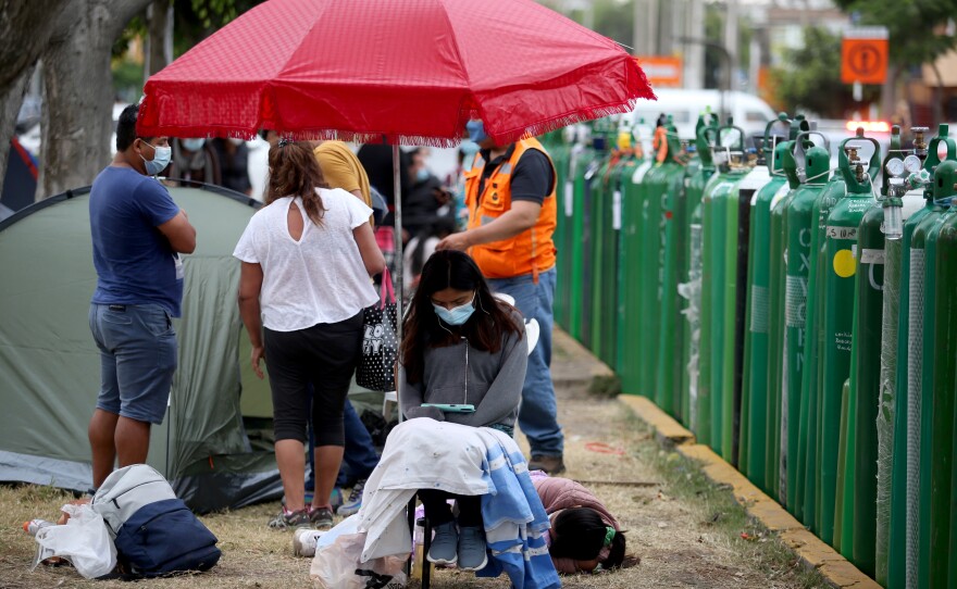 Due to the increased demand for oxygen for COVID patients, supplies have run low. Hospitals ask the friends and family of patients to wait in line to refill tanks. Above: an oxygen tank line in Lima.