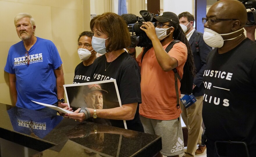 Nancy Vollertsen, center, holds a photo of her deceased brother, Greg Wilhoit, as she and Gary Drinkard, left, Juan Melendez and Herman Lindsey, right, who all spent time on death row before being exonerated, as she delivers a letter to the office of Oklahoma Gov. Kevin Stitt, requesting a speedy commutation hearing for Julius Jones, Wednesday, Sept. 1, 2021, in Oklahoma City.