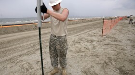 On Grand Isle, La., a fence built by the Louisiana National Guard prevents access to booms collecting oil from the Deepwater Horizon spill.