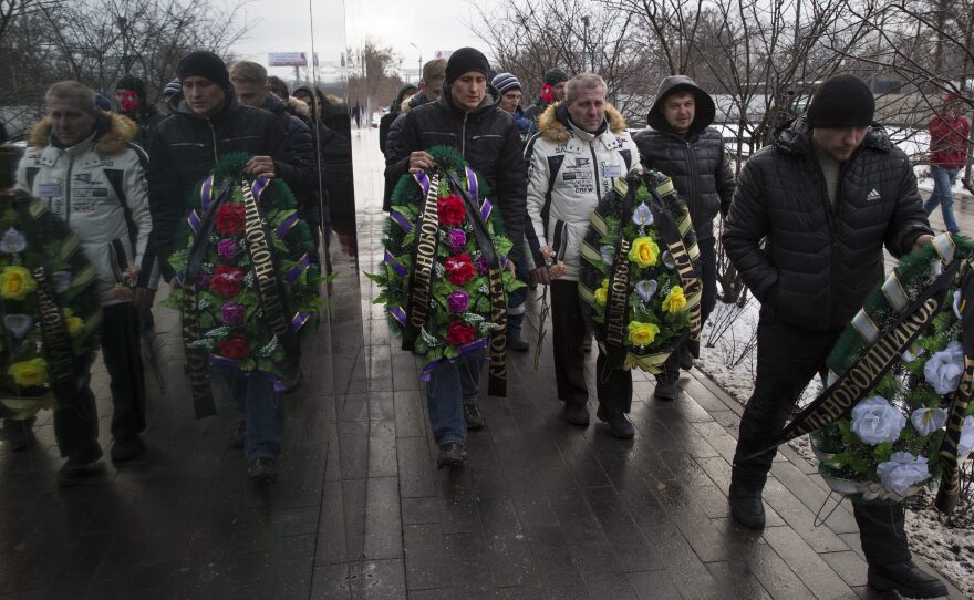 Truck drivers and their supporters walk with symbolic wreaths, which they plan to lay near an office of a new road payment system, outside Moscow on Dec. 13. Truck drivers have been protesting the new road toll for weeks.