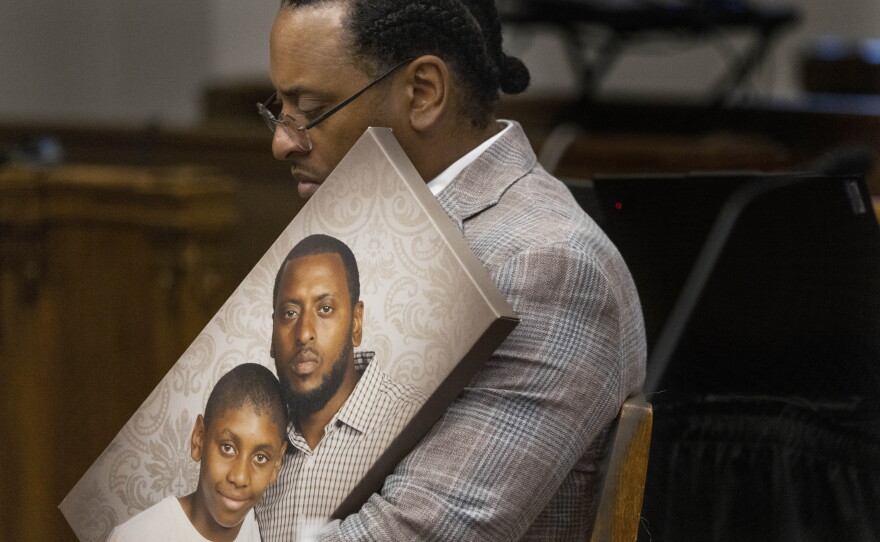 Antonio Mays Sr. holds a picture of himself and his son, Antonio Mays Jr., in Superior Court at the King County Courthouse in Seattle on Dec. 10, 2025.