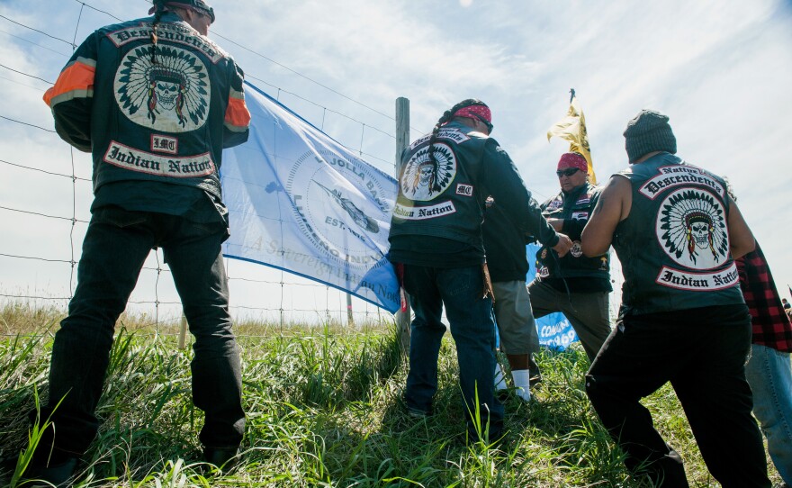 Members of Native Descendents, an all-Indian motorcycle club from Southern California, hang the La Jolla tribal flag at a construction site for the Dakota Access pipeline.