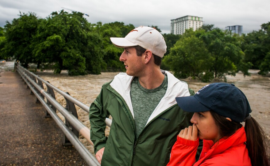 Forrest Huggleston and Alex Huff watch flooding at Shoal Creek after days of heavy rain in Austin, Texas, on Monday.