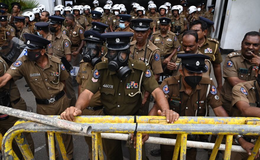 Members of police stand guard in front of the police headquarters during a protest by demonstrators demanding actions against authorities over attacks on protesters and media amid ongoing economic crisis in Colombo on July 11.