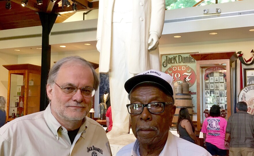 Company historian Nelson Eddy (left) stands in front of a statue of Jack Daniel with Claude Eady, a descendant of Nearis Green.