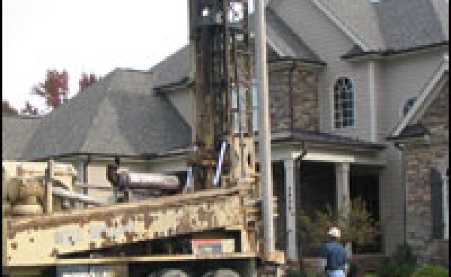 A crew drills an irrigation well in the front yard of Pericchi's two-month-old home. While the community water system in Pericchi's neighborhood has imposed restrictions on outdoor water use, the private well will allow him to water his lawn as often as he wants.