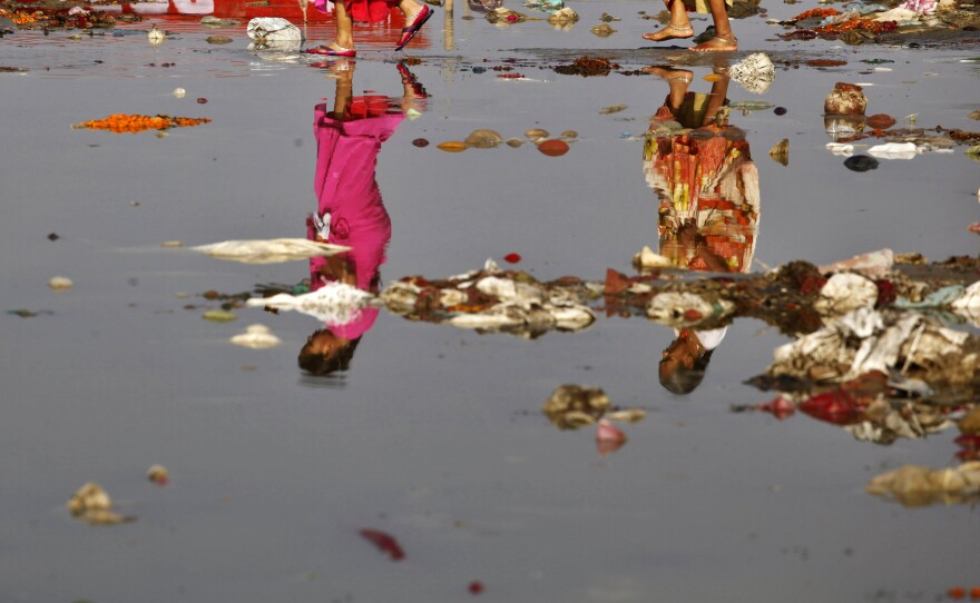 Indian Hindu devotees, reflected on the water, cross the polluted Ganges River at Sangam, the confluence of the Ganges, Yamuna, and the mythical Saraswati River, in Allahabad, India. Uttarakhand's Court conferred rights on the Yamuna when it granted rights to the Ganges.