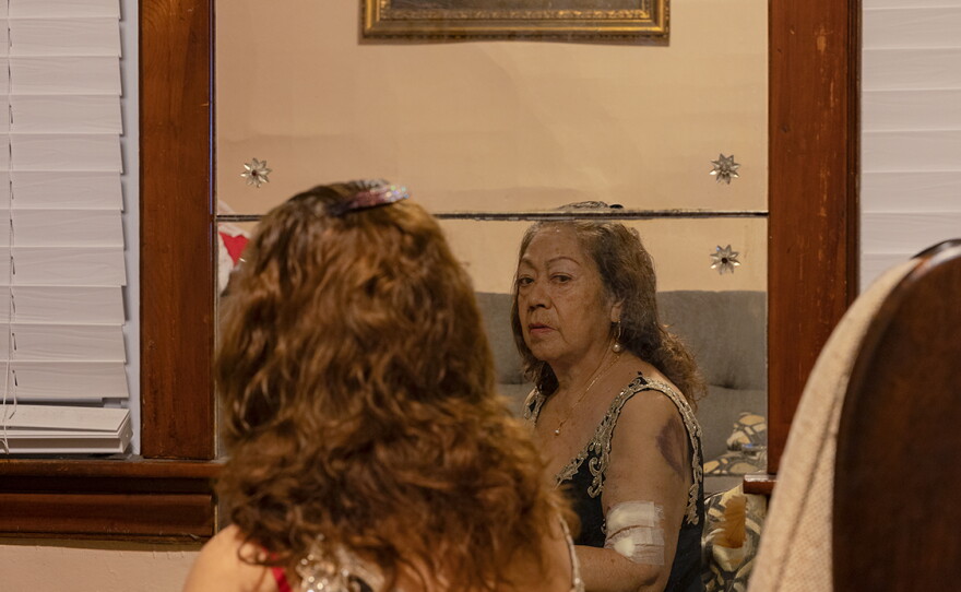 Teresa Chavez looks at herself in the mirror in 2022.