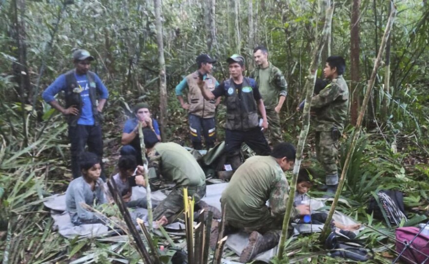 In this photo released by Colombia's Armed Forces Press Office, soldiers and Indigenous men tend to the four Indigenous brothers.