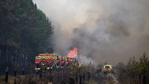 Firefighters tackle a blaze as wildfires rage near Le Las, outside Bordeaux, France, Monday, July 27, 2026.