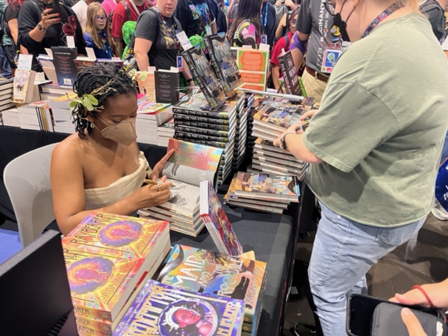 Author Jordan Ifueko signs copies of her new book "The Maid and the Crocodile" at the Mysterious Galaxy booth on July 28, 2024. San Diego Convention Center.