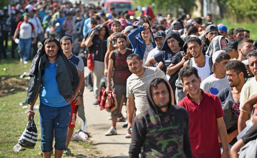 Refugees and migrants wait to board buses at Tovarnik railway station in Croatia after crossing from Serbia Friday. Officials say they were forced to close eight road border crossings Thursday after thousands of people entered the country since Hungary fenced off its border with Serbia earlier this week.