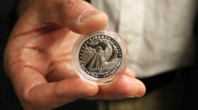 Christopher Polentz holds a coin featuring his design on Thursday, June 4, 2026.