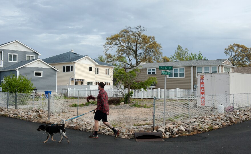 Life in the neighborhood continues on around the empty lot where Doug Quinn's house used to stand in Toms River, N.J.