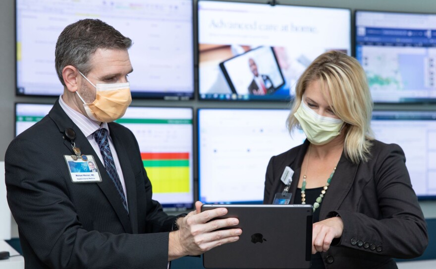 Dr. Michael Maniaci and Dr. Margaret Paulson confer at the Mayo Clinic's hospital-at-home command center in Jacksonville, Florida.