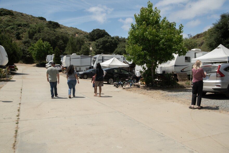 Residents of the RV park on the property of Green Oaks Ranch walk back to their trailers on June 10, 2024, in Vista, Calif.