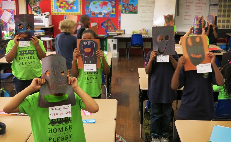 Second-graders in Chantell Nabonne's class hold up their masks, part of a class project on New Orleans's culture and art.