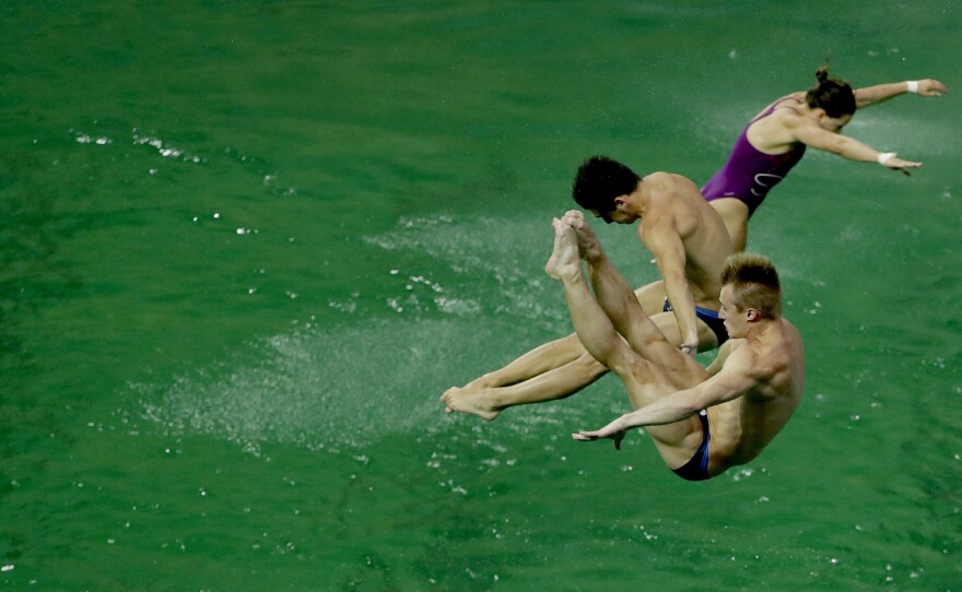 Divers take part in training before the men's synchronized 3-meter springboard diving final. The water in the pool was still green on Wednesday, but appeared to be returning to normal.