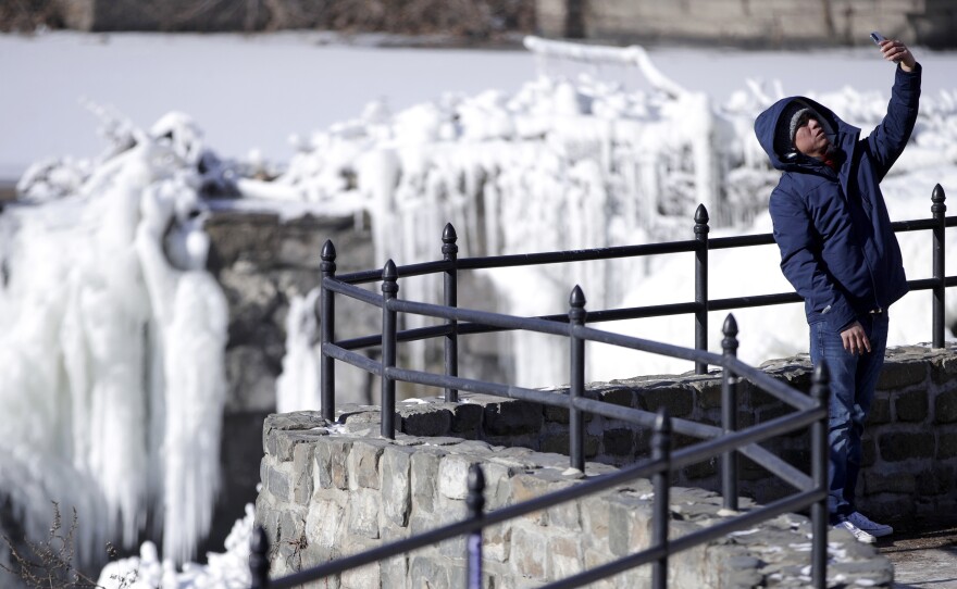 Obdulio Arenas takes a selfie at the partially frozen waterfall at the Paterson Great Falls National Historical Park, on Tuesday in Paterson, N.J.