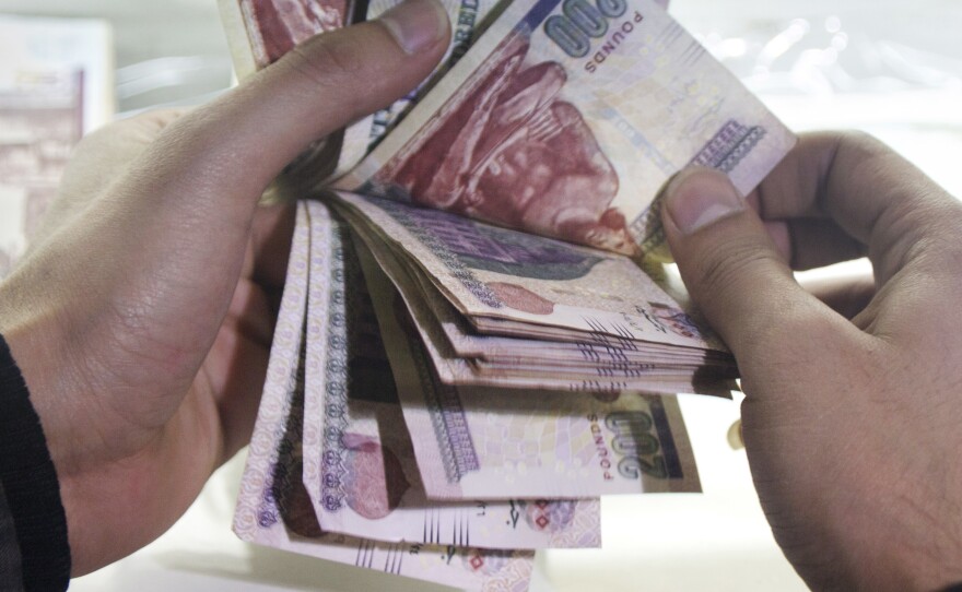 A man counts Egyptian currency at an exchange office in Cairo.