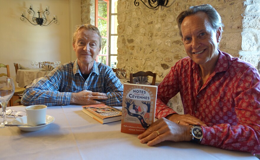 Richard E Grant (left) holds a copy of "Notes from the Cévennes" by Adam Thorpe