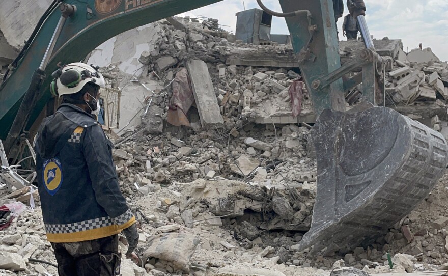 Syrian civil defense workers in the town of Jinderis dig through the rubble of a collapsed residential building in search for a 13-year-old boy and four other people on Friday.