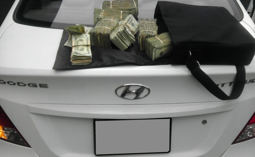 U.S Border Patrol agents seized more than $1.4 million from a 27-year-old man in a truck hauling five cars on a trailer.