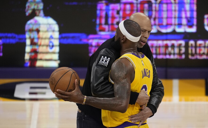 Kareem Abdul-Jabbar, left, hugs Los Angeles Lakers forward LeBron James after he surpassed Abdul-Jabbar to become the NBA's all-time leading scorer during the second half of an NBA basketball game against the Oklahoma City Thunder on  Tuesday in Los Angeles.